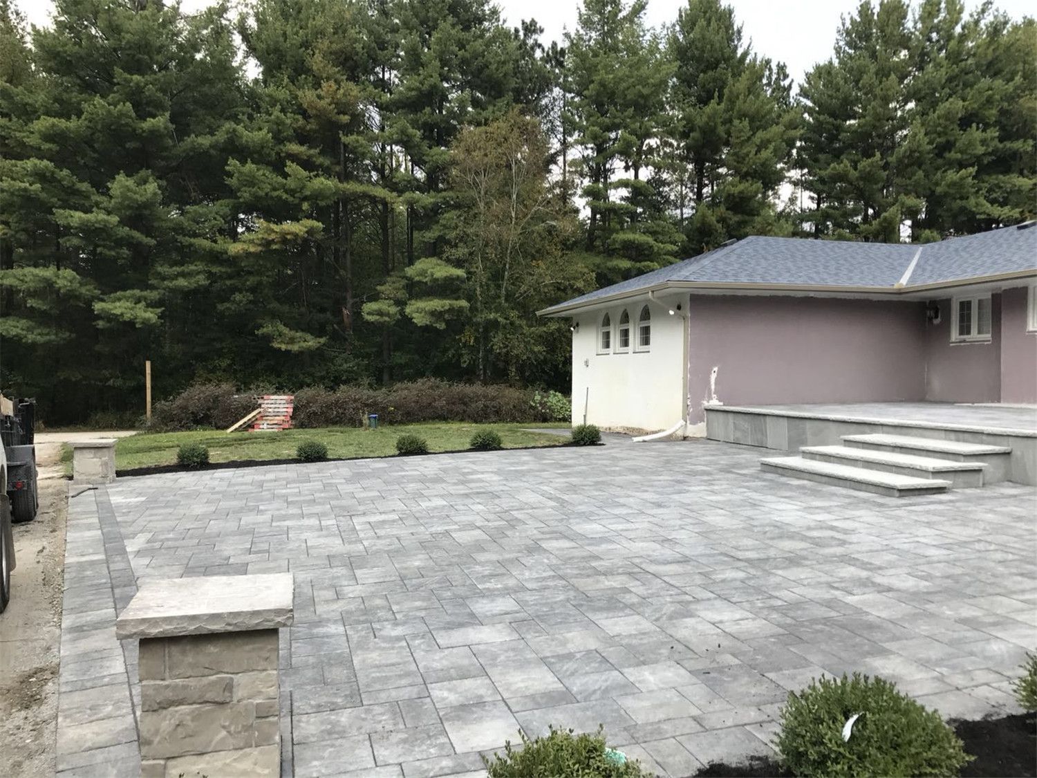 Toronto landscaping renovation featuring a spacious backyard interlock patio designed for outdoor living and entertaining. The durable paving stones, clean edges, and elevated step design create a modern and low-maintenance outdoor space that enhances both functionality and landscape aesthetics for a Toronto residential property.
