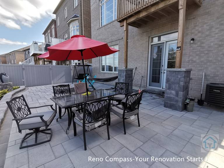 This Vaughan backyard interlocking patio features a spacious stone paver layout designed for outdoor dining and relaxation. The clean paving pattern supports patio furniture and daily use, while the open layout connects seamlessly with the deck structure and fencing, creating a comfortable and functional outdoor living space.