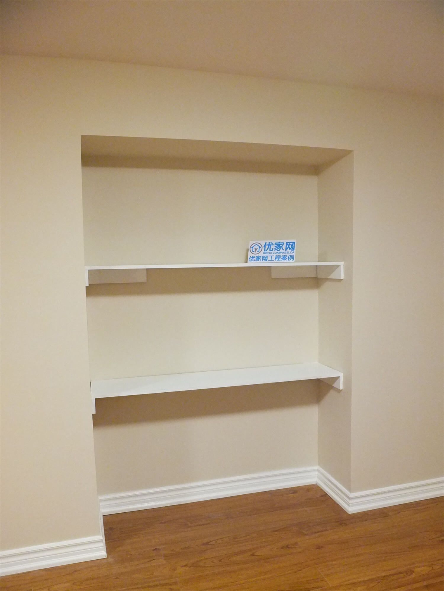 This Markham basement renovation includes a custom built-in wall shelving unit designed to add practical storage and display space. The recessed niche with clean white shelves contrasts beautifully with the warm neutral wall paint and wood-style flooring, creating a functional and visually balanced interior feature. The installation enhances basement organization while maintaining a modern and tidy interior design.