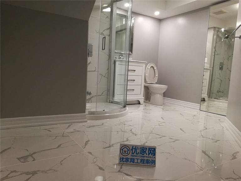 This bathroom shower renovation in New market combines elegant marble-pattern wall tiles with smaller accent tiles to create a visually balanced design. The contrast between the large marble surface and the decorative small tiles adds texture and depth while defining different areas of the shower space.