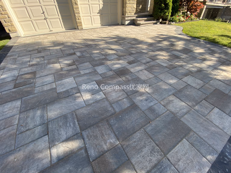 This image highlights the detailed interlocking pattern of a natural stone driveway in North York. The rectangular stone pavers are carefully aligned to create a clean, structured layout that enhances surface stability and visual consistency. Subtle color variation in the natural stone adds depth while maintaining a cohesive appearance across the driveway. Designed for durability and proper load distribution, this interlocking driveway supports everyday vehicle use and long-term performance. Completed by a Toronto interlocking and landscaping contractor, this project reflects precise installation standards and attention to paving detail.