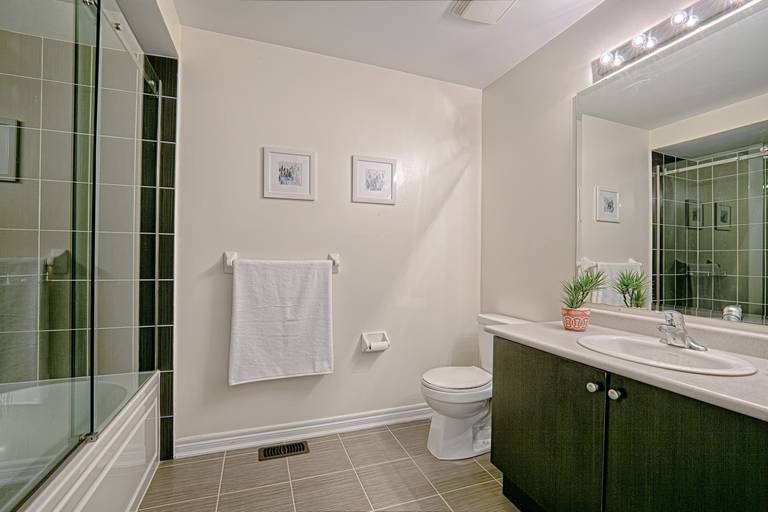 This contemporary bathroom renovation features a sleek glass-enclosed shower, modern vanity with ample storage, and a large mirror with bright overhead lighting to enhance the sense of space. Neutral wall tones and durable floor tiles create a clean and timeless design suitable for everyday living. Designed with both comfort and functionality in mind, this bathroom upgrade reflects the quality workmanship of a trusted Toronto renovation company specializing in complete residential interior renovation and modern home improvements.