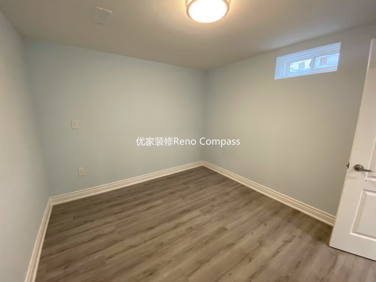 This Aurora basement renovation includes a newly finished basement bedroom completed by a professional Toronto renovation company. The space features durable modern vinyl flooring, fresh neutral wall paint, updated baseboards, and bright ceiling lighting to create a clean and comfortable living environment. A functional layout with proper window placement allows for natural light while maintaining privacy, making the room ideal for guest use, rental potential, or extended family living. Contractor: Reno Compass Inc.
