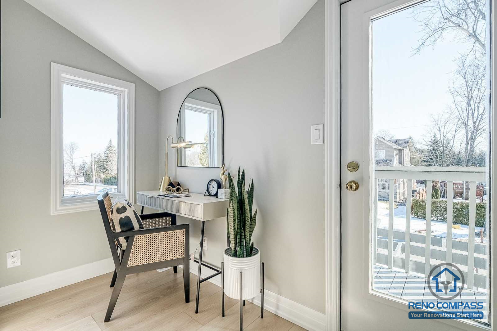 This Georgian interior renovation features a bright bedroom vanity corner with clean lines, a compact desk setup, and natural light from adjacent windows and balcony door. The thoughtful layout enhances both function and comfort, completed by a Toronto renovation company.
