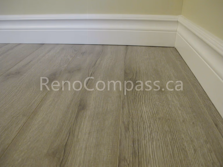 New waterproof vinyl flooring installed in this Markham basement renovation project, featuring durable wood-look planks and clean modern baseboards. Completed by Reno Compass, this basement upgrade enhances comfort, moisture resistance, and contemporary interior style for a functional finished living space.