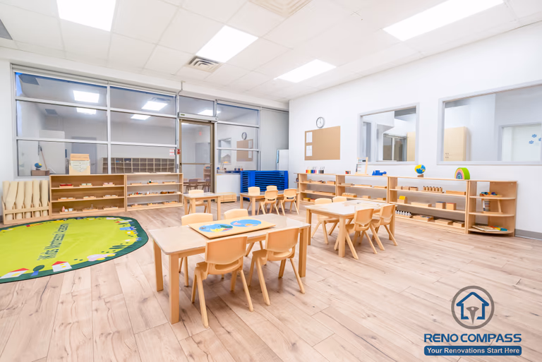 This Markham daycare renovation showcases a spacious classroom learning area designed to support group activities, early education, and daily routines. Child-sized tables and chairs are arranged to encourage collaboration while maintaining clear circulation for supervision. Open shelving and low-height cubbies provide organized storage that promotes independence and easy access for children. Durable, slip-resistant flooring and bright overhead lighting ensure safety, comfort, and long-term usability. Completed by a Toronto renovation company, Reno Compass Inc., this daycare interior renovation reflects a thoughtful balance of educational functionality, safety compliance, and efficient space planning for modern childcare environments.