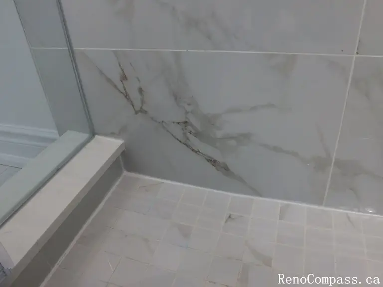 This Richmond Hill bathroom renovation highlights premium marble-look wall tiles and slip-resistant shower flooring for a clean and modern finish. Completed by a professional Toronto renovation company, the detailed tile installation enhances durability, water resistance, and visual elegance. The seamless glass shower base and neutral tones create a refined, spa-like atmosphere while ensuring long-term performance and easy maintenance.
