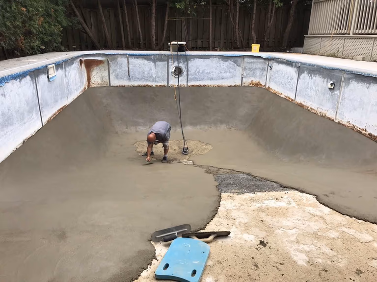 Professional swimming pool restoration in Toronto featuring concrete base repair and resurfacing work. This stage highlights structural repair, leveling, and new concrete application to strengthen the pool foundation and prepare for final finishing, ensuring long-term durability and performance for a residential pool renovation project.
