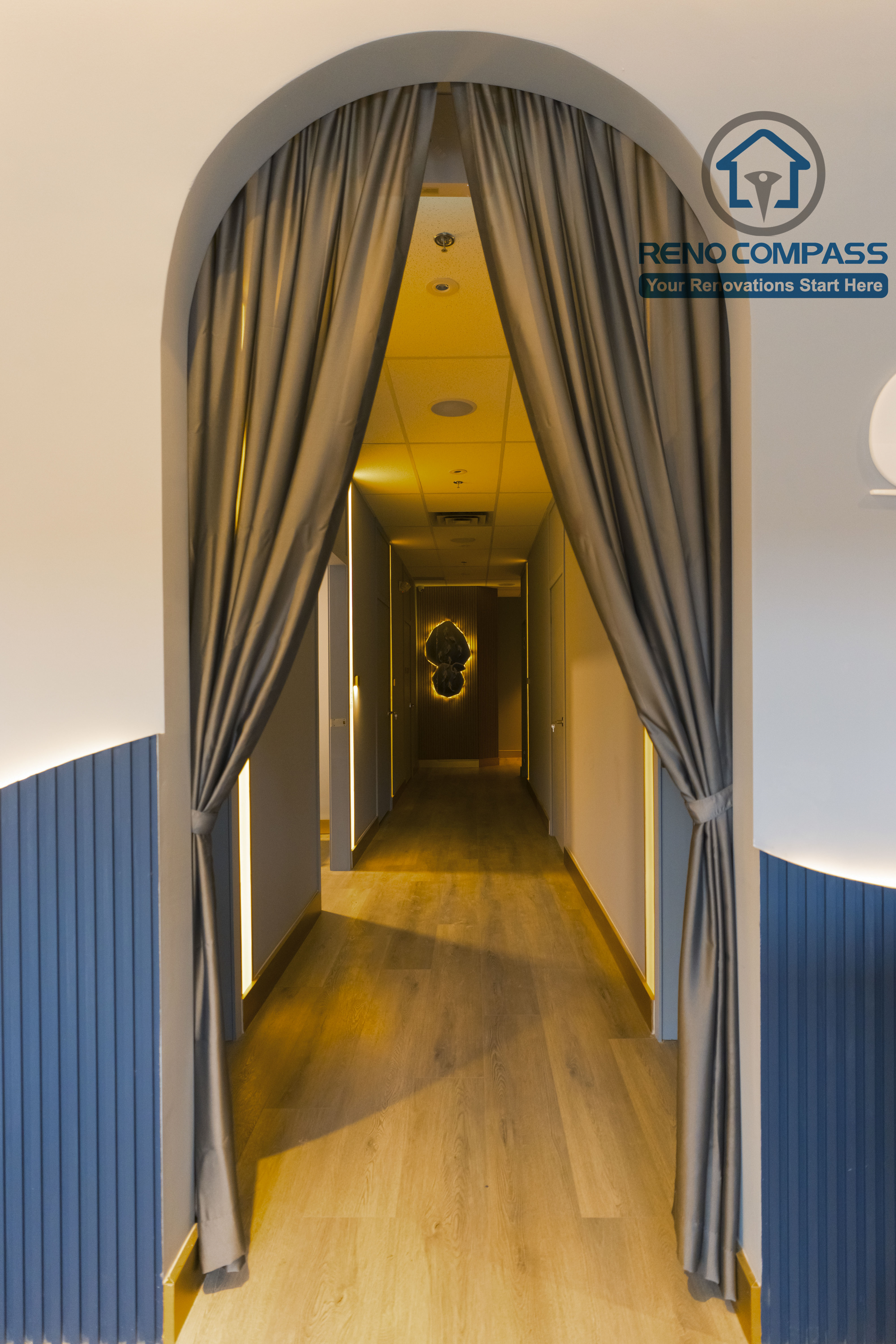 Treatment area corridor completed as part of a North York beauty salon renovation. This design features an arched entry with soft drapery, warm recessed lighting, and wood flooring that guides clients smoothly into private treatment rooms. The layout enhances privacy, circulation, and a calm spa-like experience, delivered by a professional Toronto renovation company.