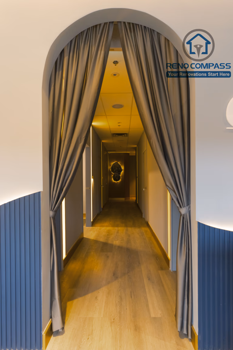 Treatment area corridor completed as part of a North York beauty salon renovation. This design features an arched entry with soft drapery, warm recessed lighting, and wood flooring that guides clients smoothly into private treatment rooms. The layout enhances privacy, circulation, and a calm spa-like experience, delivered by a professional Toronto renovation company.
