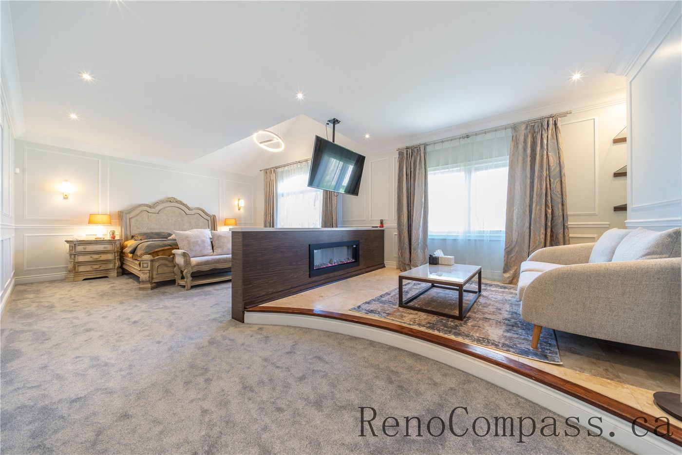 This Richmond Hill entire house interior renovation features a spacious master bedroom suite with a cozy sitting area, built-in fireplace feature, and elegant wall paneling. Soft carpeting, large windows, and warm lighting create a comfortable and luxurious retreat designed for relaxation. Completed by a trusted Toronto renovation company, this master bedroom renovation combines modern comfort, refined finishes, and functional layout to elevate everyday living.