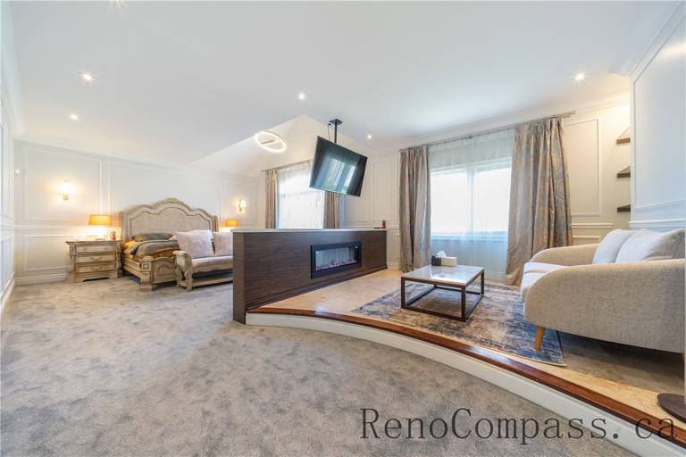 This Richmond Hill entire house interior renovation features a spacious master bedroom suite with a cozy sitting area, built-in fireplace feature, and elegant wall paneling. Soft carpeting, large windows, and warm lighting create a comfortable and luxurious retreat designed for relaxation. Completed by a trusted Toronto renovation company, this master bedroom renovation combines modern comfort, refined finishes, and functional layout to elevate everyday living.