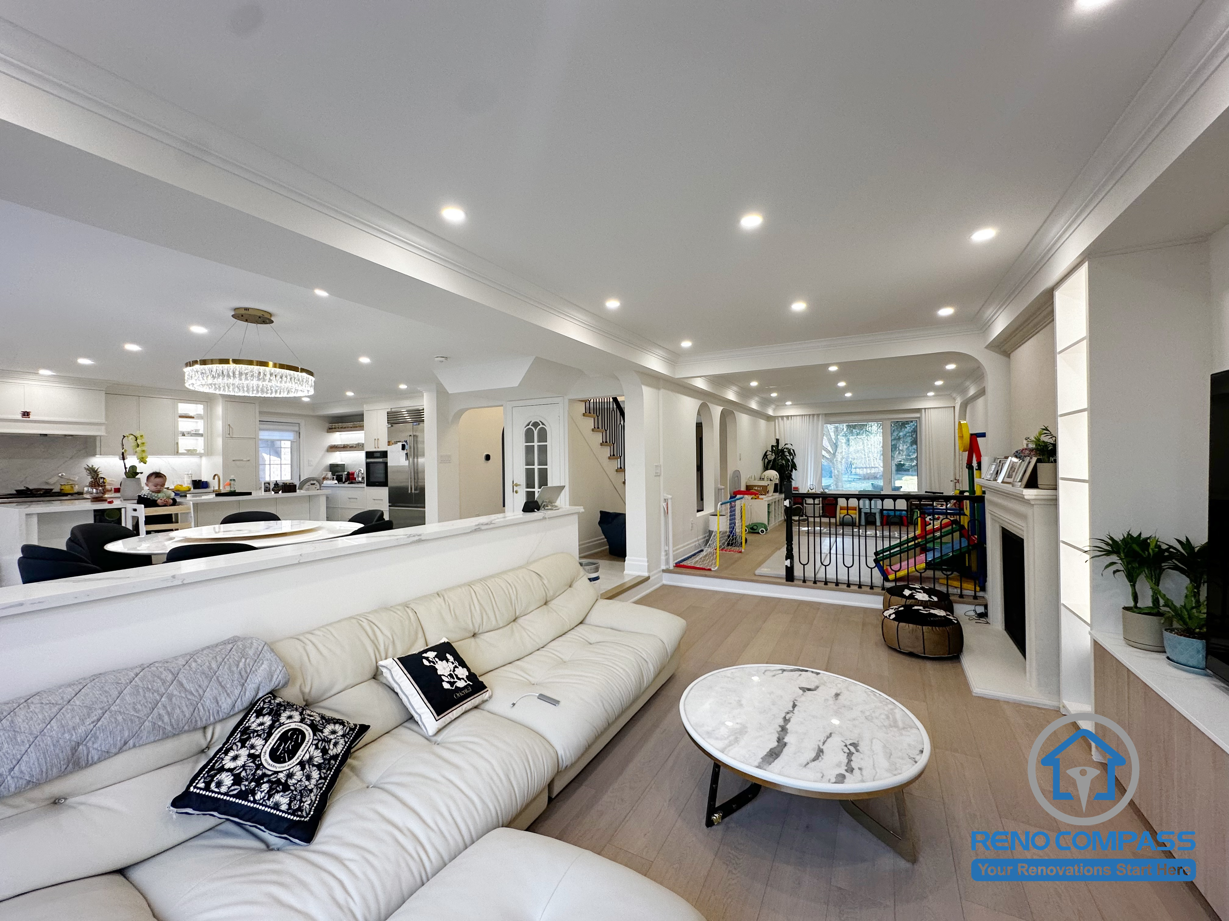 This Markham interior renovation reimagines the main living area as a bright, open-concept space that seamlessly connects lounging, dining, and family activity zones. The layout is designed to enhance visual continuity while maintaining comfortable separation between different functions of the home.

A half-height partition helps define the living room without blocking sightlines, allowing natural light to flow through the space. Recessed ceiling lighting and consistent architectural details create a clean, cohesive look throughout the interior. The open connection to the kitchen and family areas supports everyday interaction and makes the space ideal for both relaxation and entertaining.

By focusing on layout balance, lighting design, and long-term usability, this renovation delivers a refined yet practical interior environment suited for modern family living in Markham.