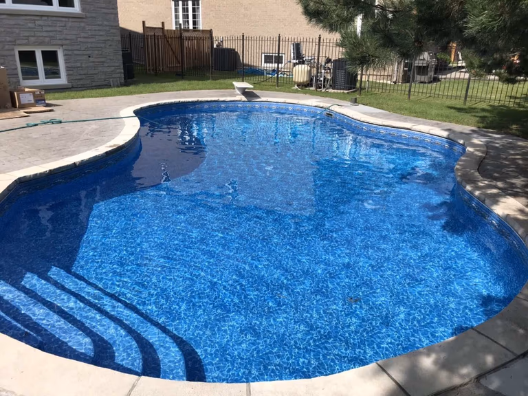 Beautifully renovated backyard swimming pool in Toronto. The new pool liner, resurfaced edges, and crystal-clear water showcase a complete transformation from old to new. Expert pool remodeling for modern outdoor living and relaxation.