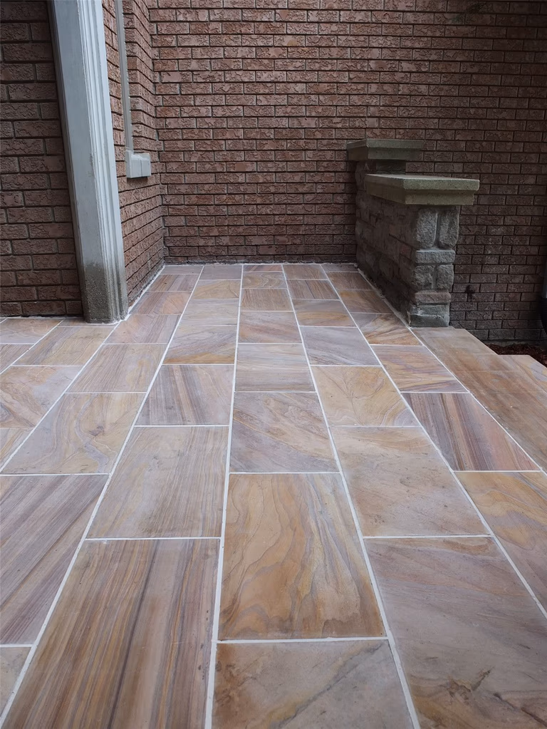 This Richmond Hill front entrance renovation showcases a newly installed interlocking stone porch with durable natural-tone tiles and clean modern finishing. The upgraded entrance landing improves safety, drainage, and curb appeal while complementing the home’s brick exterior and stone pillars. Completed by a trusted Toronto renovation company, this landscaping and interlocking project delivers a refined, long-lasting front entry designed for both functionality and visual impact.