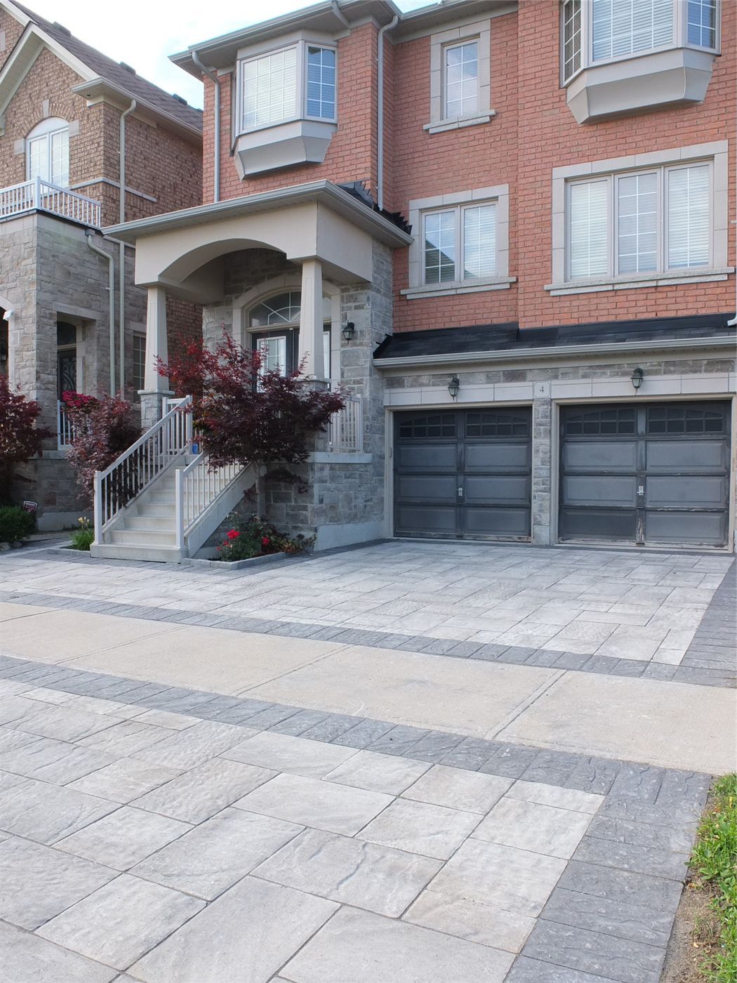 This Toronto landscaping renovation features a professionally designed interlocking driveway and front entrance upgrade that enhances curb appeal and durability. The project includes large-format stone interlocking, clean border detailing, and a modern front stairway with white railings, creating a refined and welcoming exterior. Completed by an experienced Toronto renovation and landscaping team, the design combines functionality, drainage planning, and long-term stability while delivering a clean, elegant residential look perfect for modern homes.