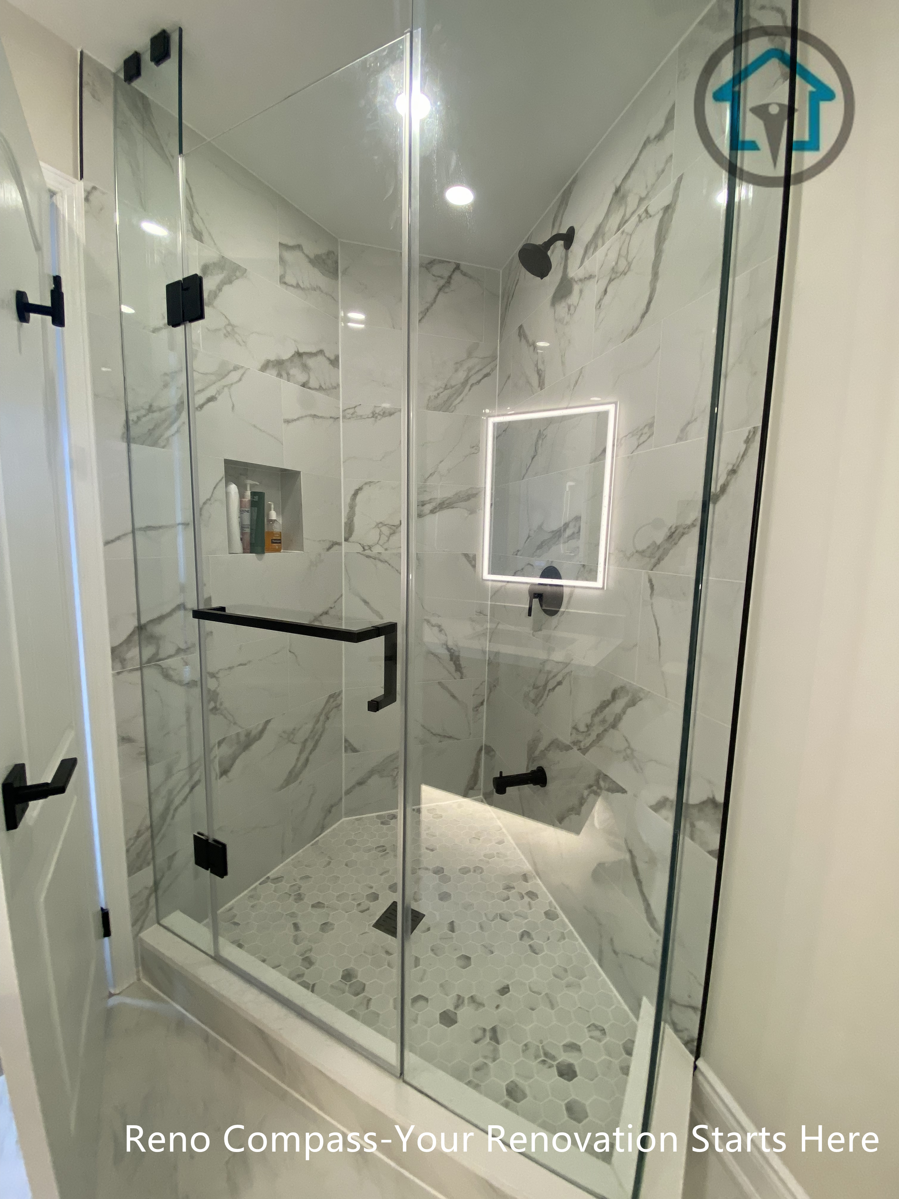 This newly created secondary bathroom in Richmond Hill features a sleek frameless glass shower with marble-style wall tiles and a pebble-finish shower base for a spa-inspired look. Matte black fixtures, recessed niche storage, and soft LED mirror lighting enhance both functionality and modern aesthetics. As part of a one-bathroom-to-two conversion, this upgrade maximizes space efficiency and home value, completed by a professional Toronto renovation company with attention to detail and quality craftsmanship.
