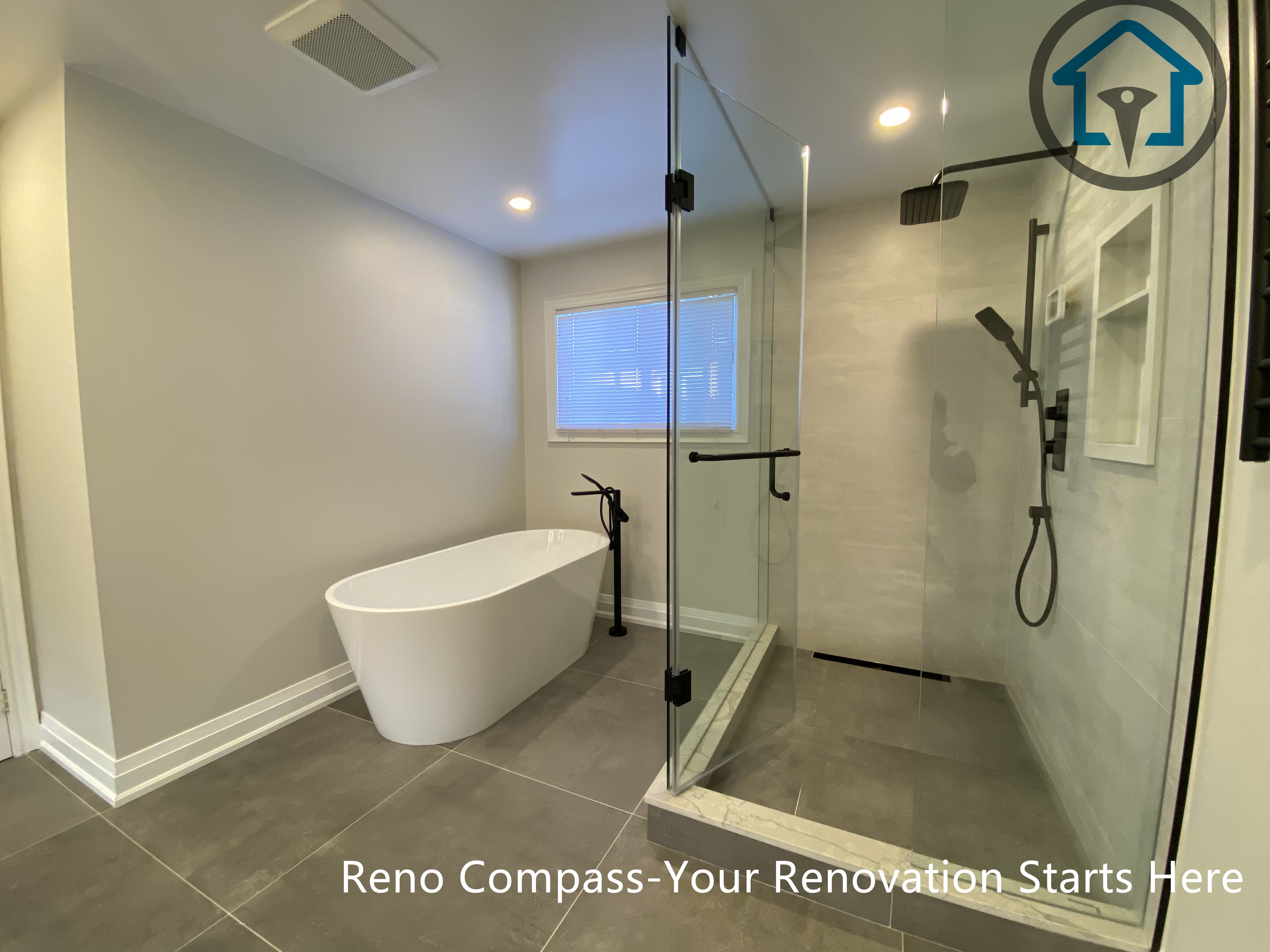 Spacious bathroom renovation in Markham featuring a frameless glass walk-in shower, freestanding soaking tub, large-format floor tiles, and modern matte black fixtures. The layout emphasizes comfort, functionality, and a clean contemporary aesthetic completed by a professional Toronto renovation company.