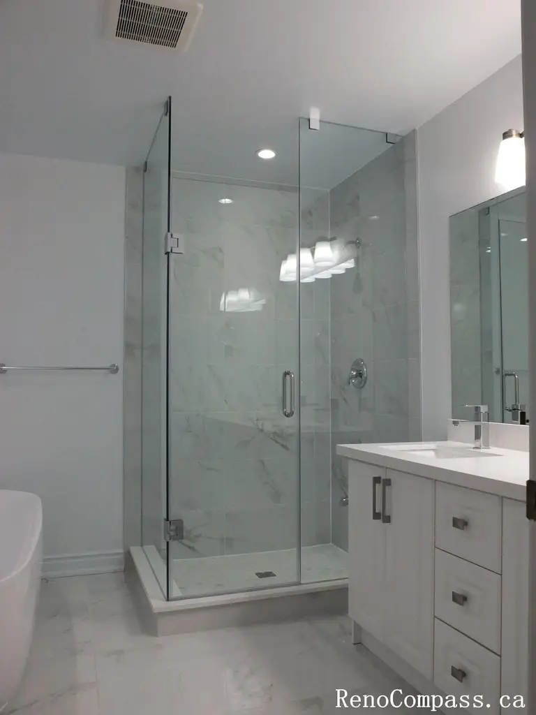This Richmond Hill bathroom renovation features a sleek glass-enclosed shower, marble-look wall tiles, and a modern white vanity with quartz countertop. Completed by a professional Toronto renovation company, the space was redesigned to enhance brightness, functionality, and everyday comfort. Clean lines, neutral tones, and contemporary fixtures create a fresh, elegant bathroom environment built for long-term durability and style.