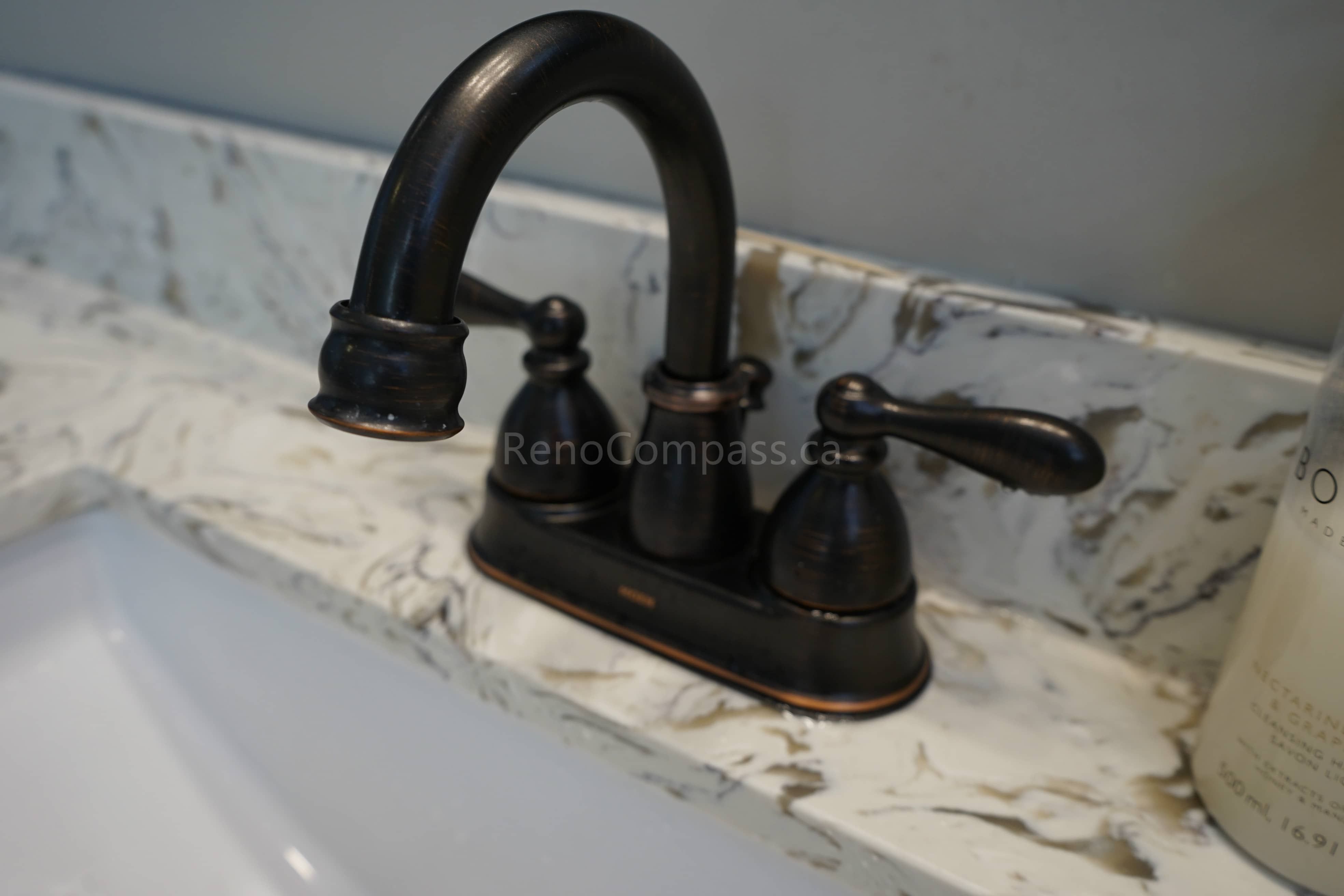 Close-up of a stylish matte black bathroom faucet installed on a quartz countertop in this Markham bathroom renovation. The modern fixture and elegant stone surface create a refined, contemporary look while improving durability and everyday functionality for homeowners.