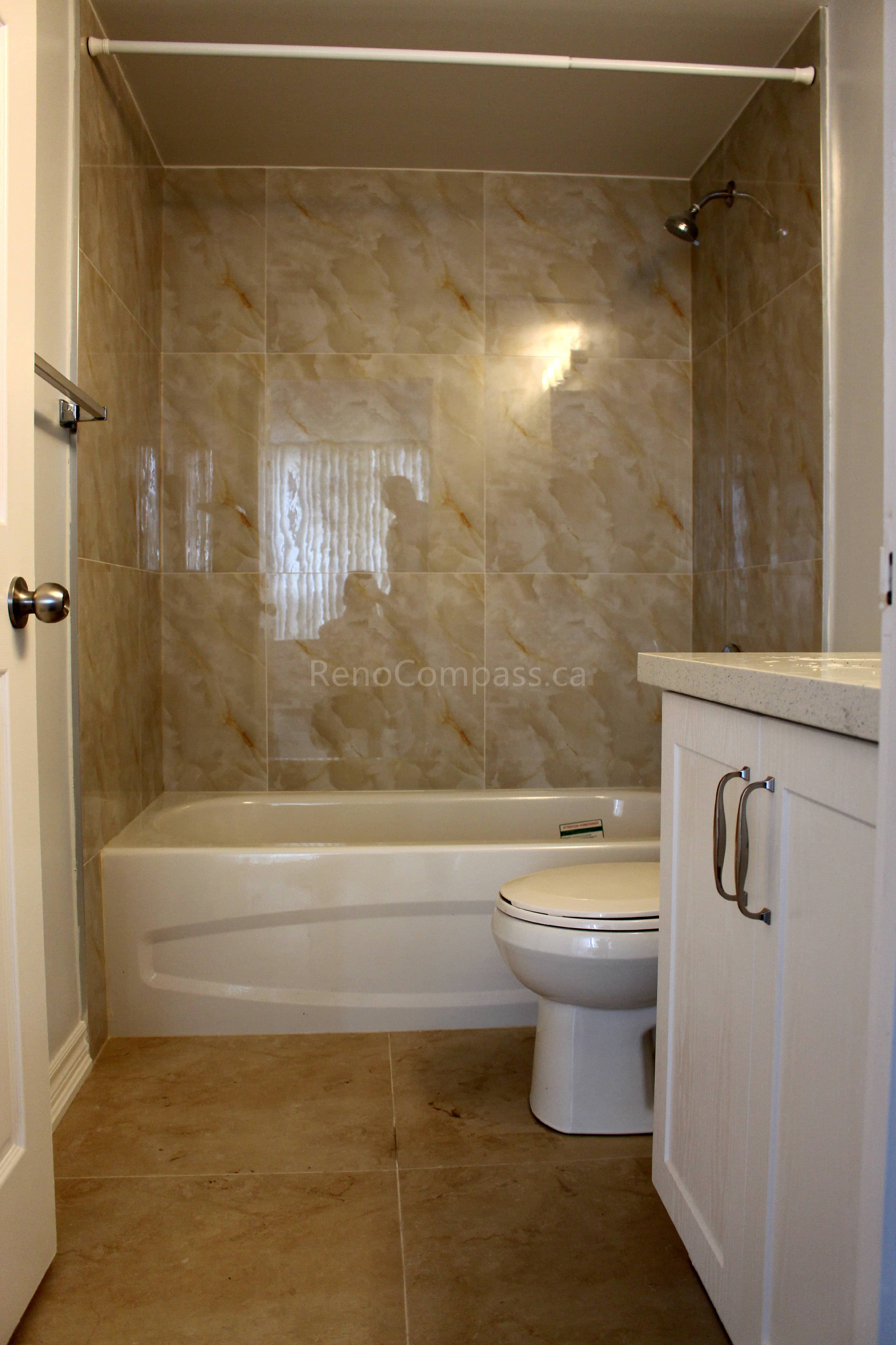 This Mississauga interior renovation project features a clean and functional bathroom upgrade with a modern bathtub, full-height marble-style wall tiles, new vanity cabinet, and upgraded flooring. Completed by Reno Compass, a professional Toronto renovation company, the design focuses on durability, easy maintenance, and practical daily use for homeowners in the GTA.