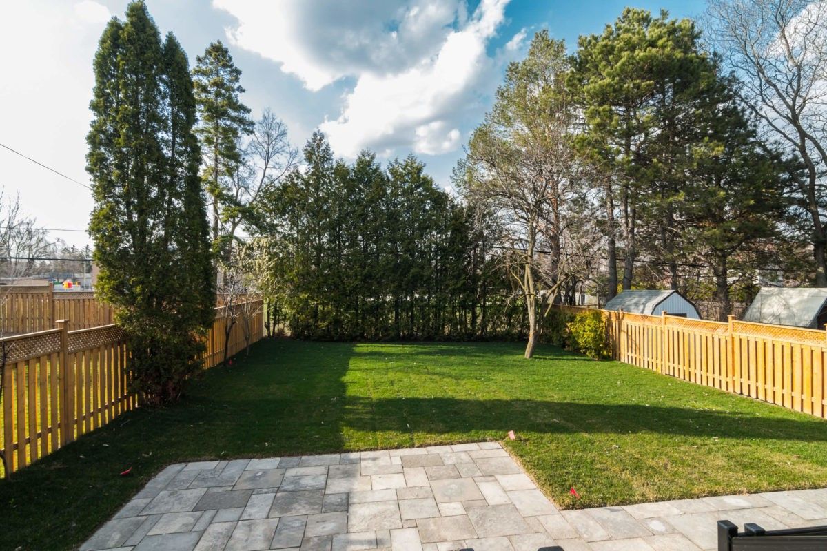 The exterior of this 4,500 sq ft Toronto luxury home renovation features a spacious backyard with professional landscaping and a custom interlock patio. Clean paving lines and a well-planned lawn create an inviting outdoor living space that complements the modern interior design. This project was completed by a trusted Toronto Renovation Company, Reno Compass Inc., delivering a seamless transition between indoor comfort and outdoor functionality for contemporary family living.
