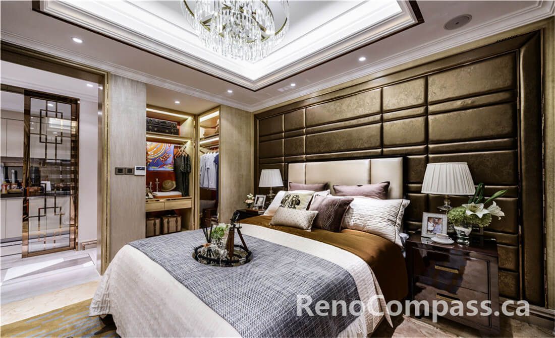 This Toronto interior renovation presents an upscale bedroom design featuring a custom upholstered feature wall, elegant tray ceiling with crystal chandelier, and a seamless connection to a walk-in closet and ensuite area. Warm lighting, tailored cabinetry, and premium finishes create a calm yet luxurious retreat. Completed by a trusted Toronto Renovation Company, the project reflects expert craftsmanship, thoughtful storage planning, and refined residential interior styling designed for comfort, functionality, and timeless appeal.