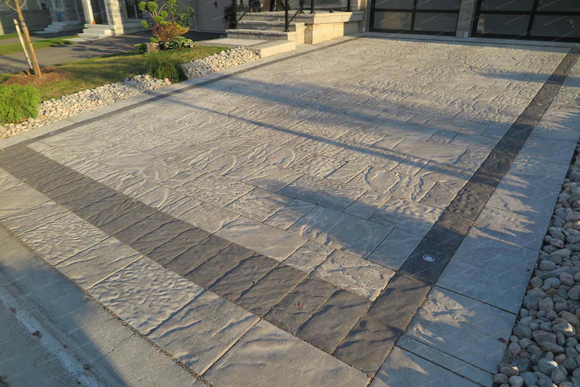 Stamped concrete driveway renovation for a detached home in Vaughan featuring natural stone texture patterns and a contrasting decorative border. This front yard hardscaping design provides a durable, low-maintenance driveway while enhancing the property’s modern curb appeal and overall landscape layout.