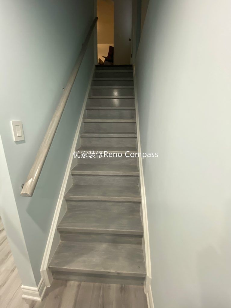This Aurora basement renovation includes a newly upgraded staircase completed by a professional Toronto renovation company. The stairs feature durable modern vinyl step finishes, updated white trim, and a secure contemporary handrail for safety and style. Clean lines and coordinated flooring seamlessly connect the basement to the upper level, creating a cohesive and polished transition that enhances both functionality and overall home value. Contractor: Reno Compass Inc.