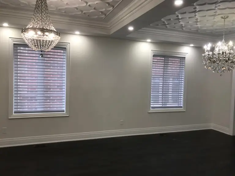 Custom zebra blinds installation in Toronto dining room by professional Toronto renovation company Reno Compass Inc. Featuring dual-layer light filtering shades, clean white window trim, modern chandelier lighting, and elegant wall panel detailing. This window treatment upgrade enhances privacy, natural light control, and interior aesthetics with a sleek and contemporary finish.