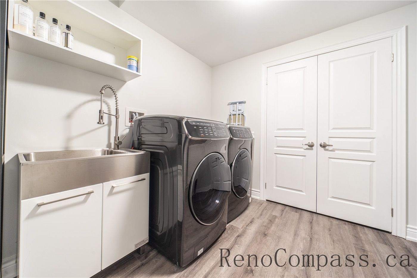 This Richmond Hill entire house interior renovation includes a clean and functional laundry room with modern washer and dryer units, a utility sink, and custom storage cabinetry. Durable flooring, bright lighting, and organized shelving enhance efficiency and everyday convenience. Completed by a professional Toronto renovation company, this laundry room renovation combines practicality, comfort, and contemporary design for improved home functionality.