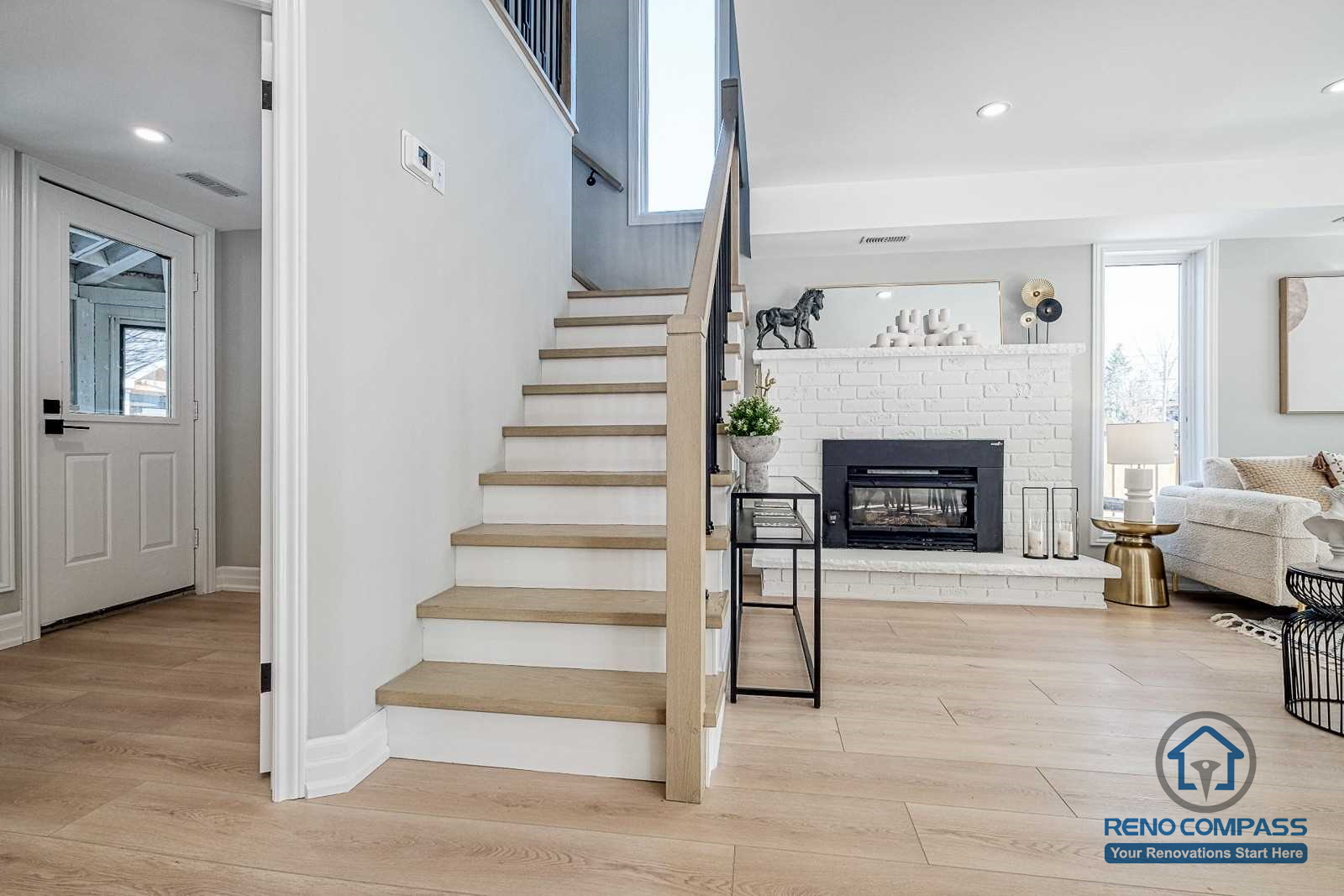 This Georgian interior renovation features a refined staircase design with light wood treads, clean railings, and a clear view toward the living room fireplace. The layout balances classic structure with modern finishes, completed by a Toronto renovation company.