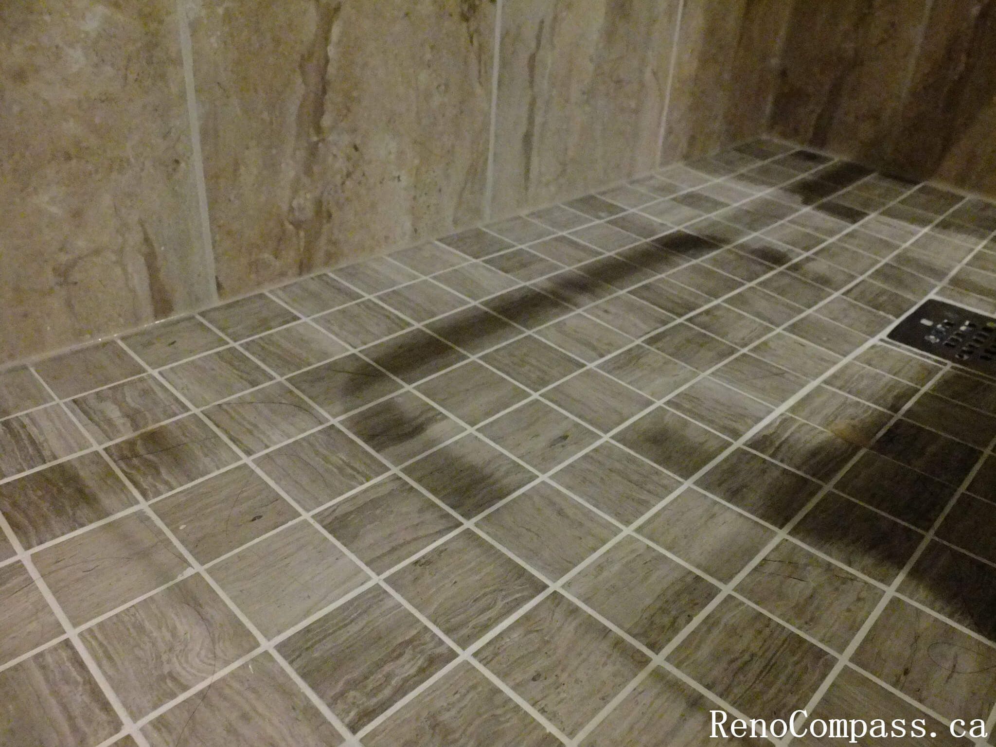 Close-up view of shower floor tile installation from a North York bathroom renovation, highlighting slip-resistant mosaic tiles, proper slope, clean grout lines, and integrated floor drain detailing.