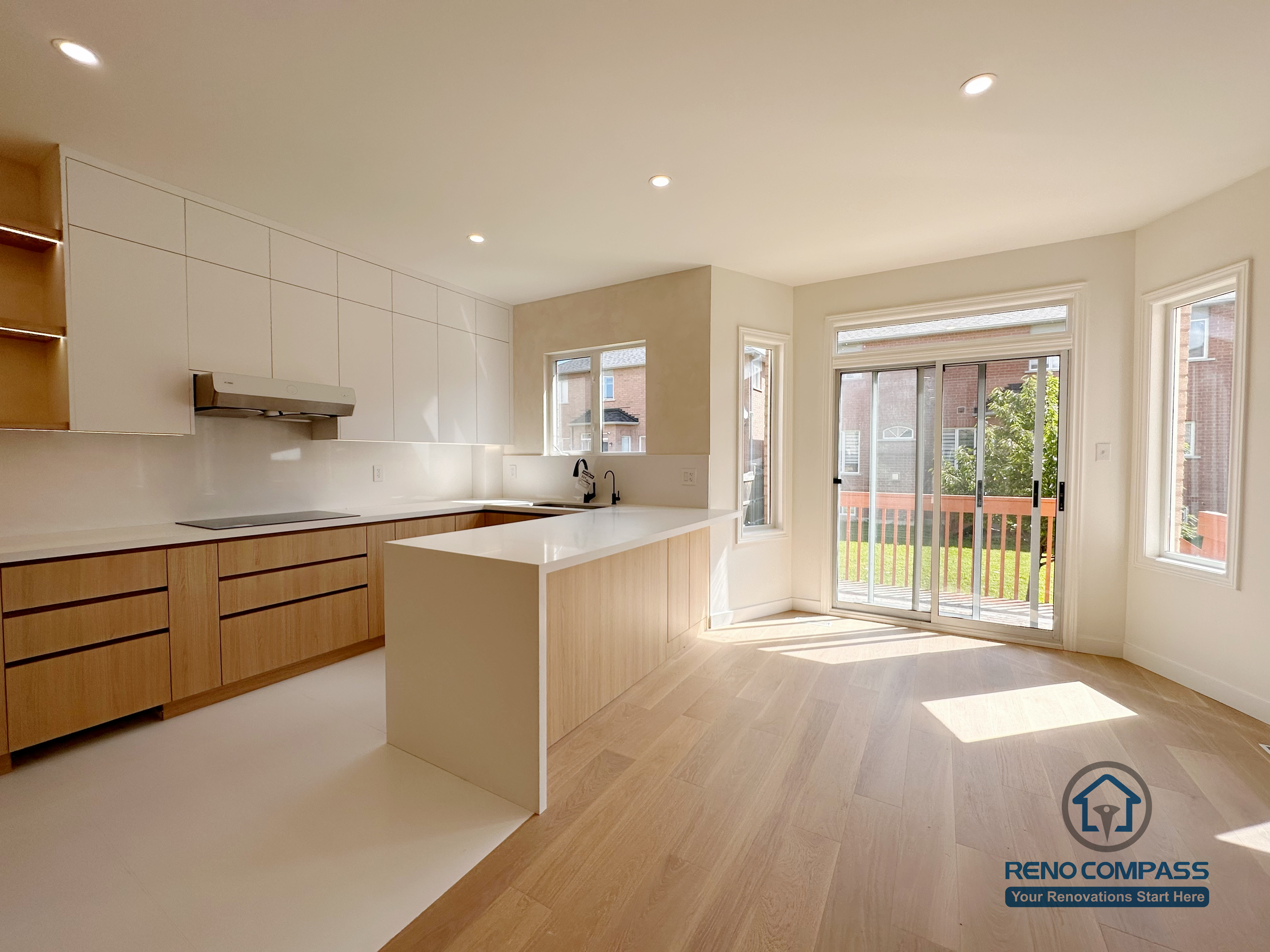 Open-concept kitchen renovation in Markham featuring a large island, custom cabinetry, and seamless connection to the dining area. The layout enhances natural light, improves circulation, and creates a bright, functional space suitable for everyday cooking and family gatherings.