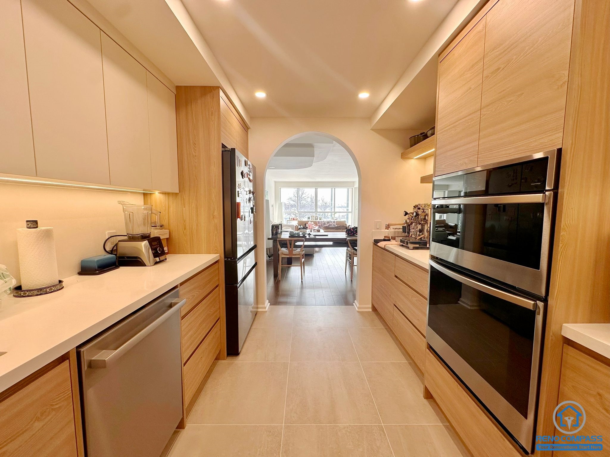 This Toronto condo interior renovation showcases custom-built wood kitchen cabinets paired with a refined arch feature and upgraded lighting. The result is a stylish, functional, and airy kitchen that maximizes storage while delivering a high-end modern condo living experience.