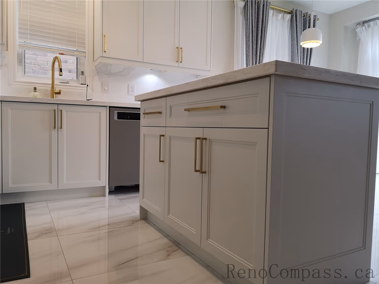 This Aurora kitchen renovation showcases a modern and elegant layout with custom white shaker cabinets, quartz countertops, marble-style backsplash, and stylish brushed gold hardware. Under-cabinet lighting enhances both functionality and ambiance, while the centered window sink design creates a bright and balanced workspace. Completed by a professional Toronto renovation company focused on quality craftsmanship, timeless design, and practical everyday living.