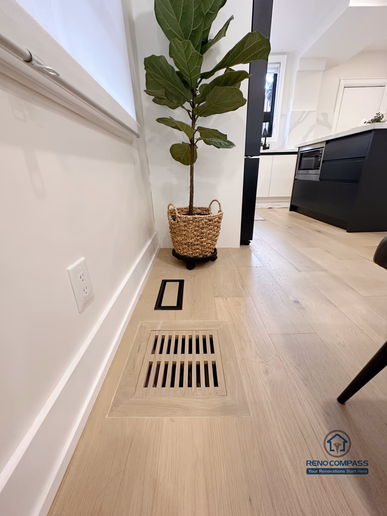 This Toronto interior renovation showcases detailed hardwood flooring installation with a flush-mounted floor vent, clean baseboard finishes, and precise craftsmanship. The seamless integration of ventilation, flooring, and interior elements reflects the attention to detail expected from a professional Toronto renovation company in modern residential projects.