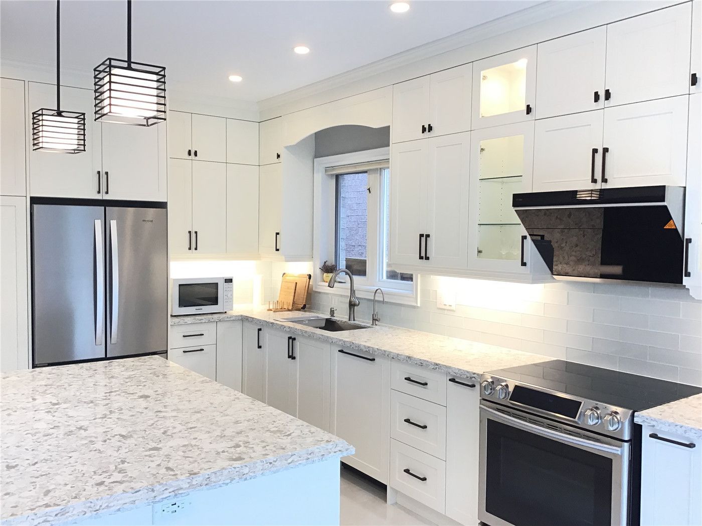 This Richmond Hill kitchen renovation showcases a clean and functional layout featuring custom white cabinetry, quartz countertops, and premium stainless steel appliances. The design is complemented by modern pendant lighting, under-cabinet illumination, and a spacious island ideal for daily use and entertaining. Completed by a trusted Toronto renovation company, this project highlights a perfect balance of style, efficiency, and long-term durability.