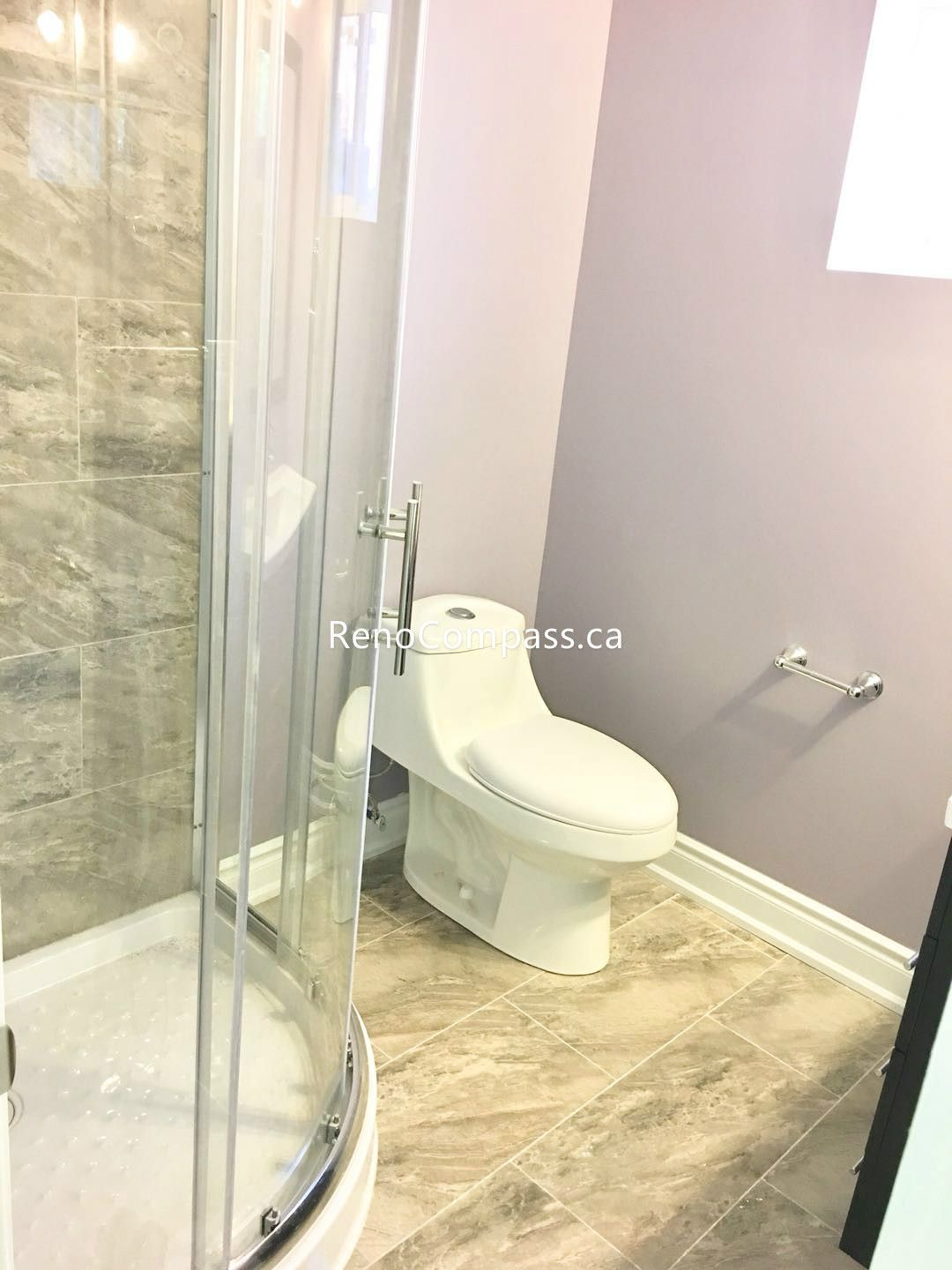 This Toronto basement renovation features a newly finished bathroom with a modern glass shower enclosure, sleek toilet installation, and durable stone-look tile flooring and walls. The clean layout and neutral tones create a bright, functional, and contemporary basement bathroom. Completed by a professional Toronto renovation company, this upgrade enhances comfort, usability, and overall property value with quality craftsmanship and practical design.