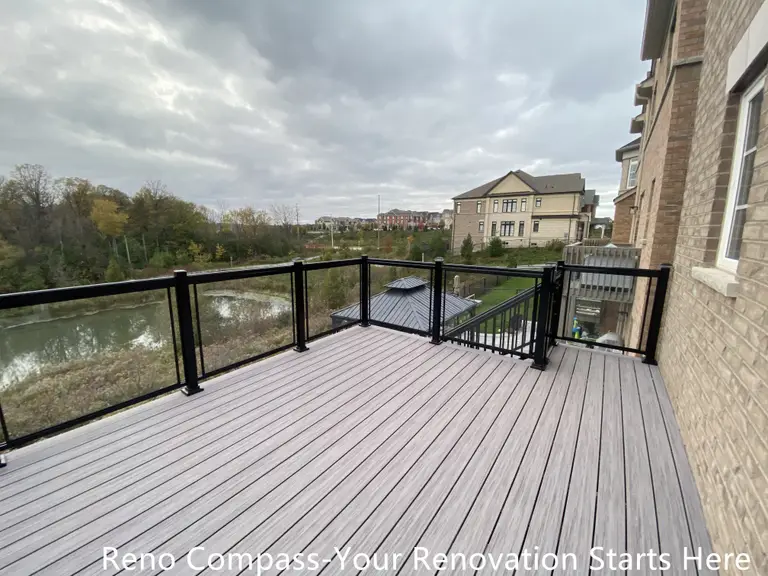 Modern Aurora deck featuring durable wooden flooring and sleek glass railings, designed for outdoor leisure, family gatherings, and seamless integration with the home exterior. Project by Reno Compass Inc.