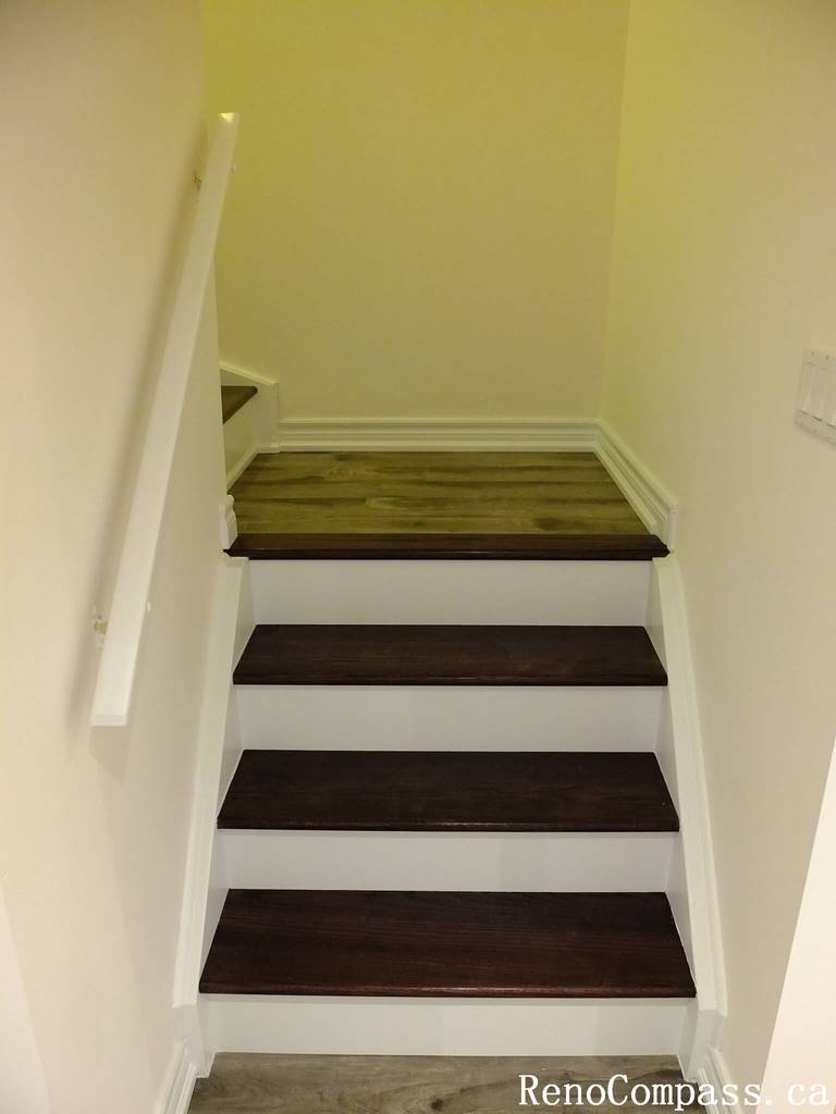 This Markham basement renovation showcases newly finished basement stairs featuring rich wood treads, white risers, and a clean modern handrail. The upgraded staircase enhances safety, durability, and visual continuity, seamlessly connecting the main floor to the newly renovated basement space.