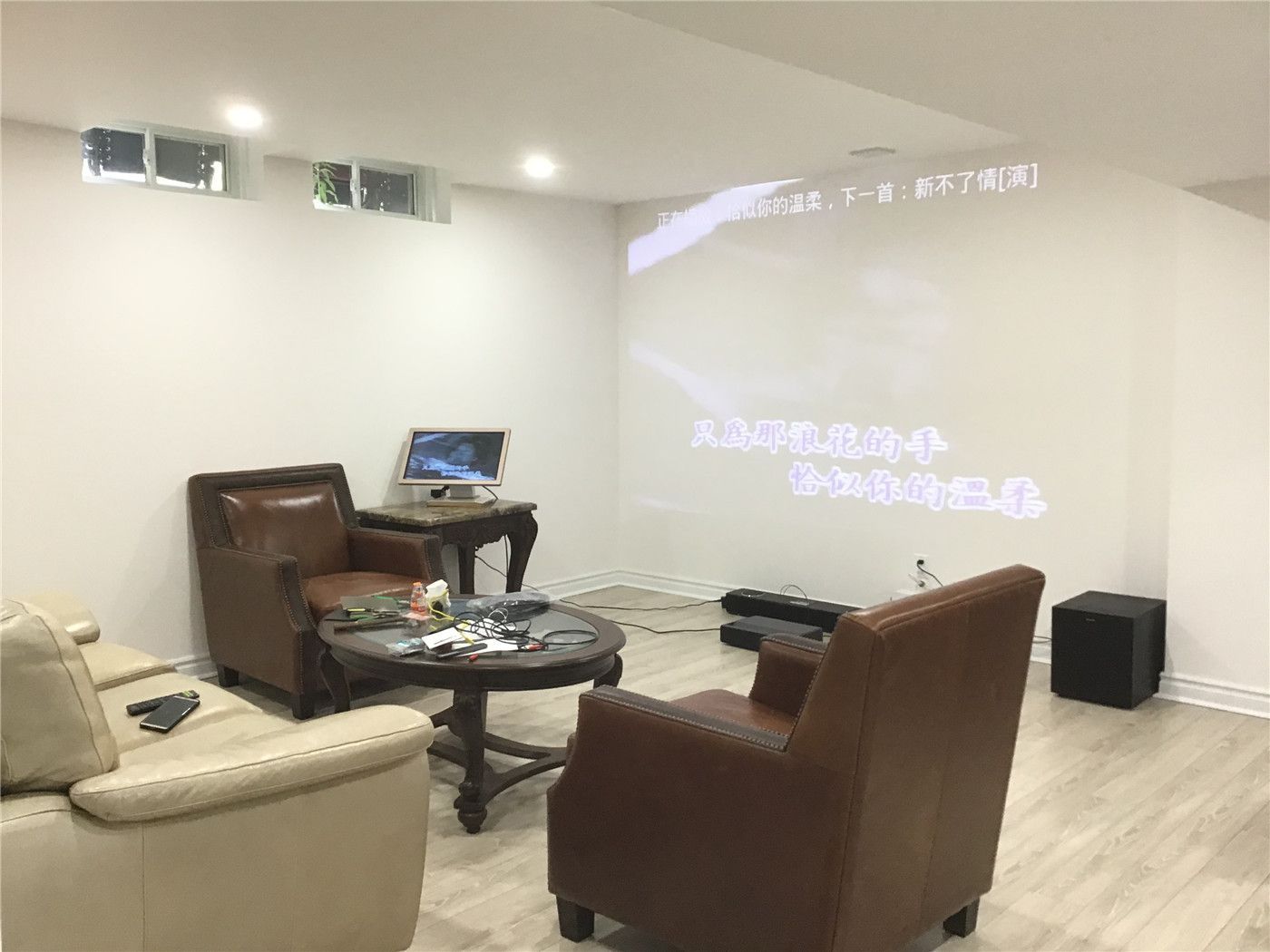 This Aurora basement renovation highlights a cozy home theater setup with a projector screen, comfortable seating, and a relaxed lounge atmosphere. The space is designed for entertainment and everyday living, featuring warm lighting, soft-toned flooring, and an inviting open layout.