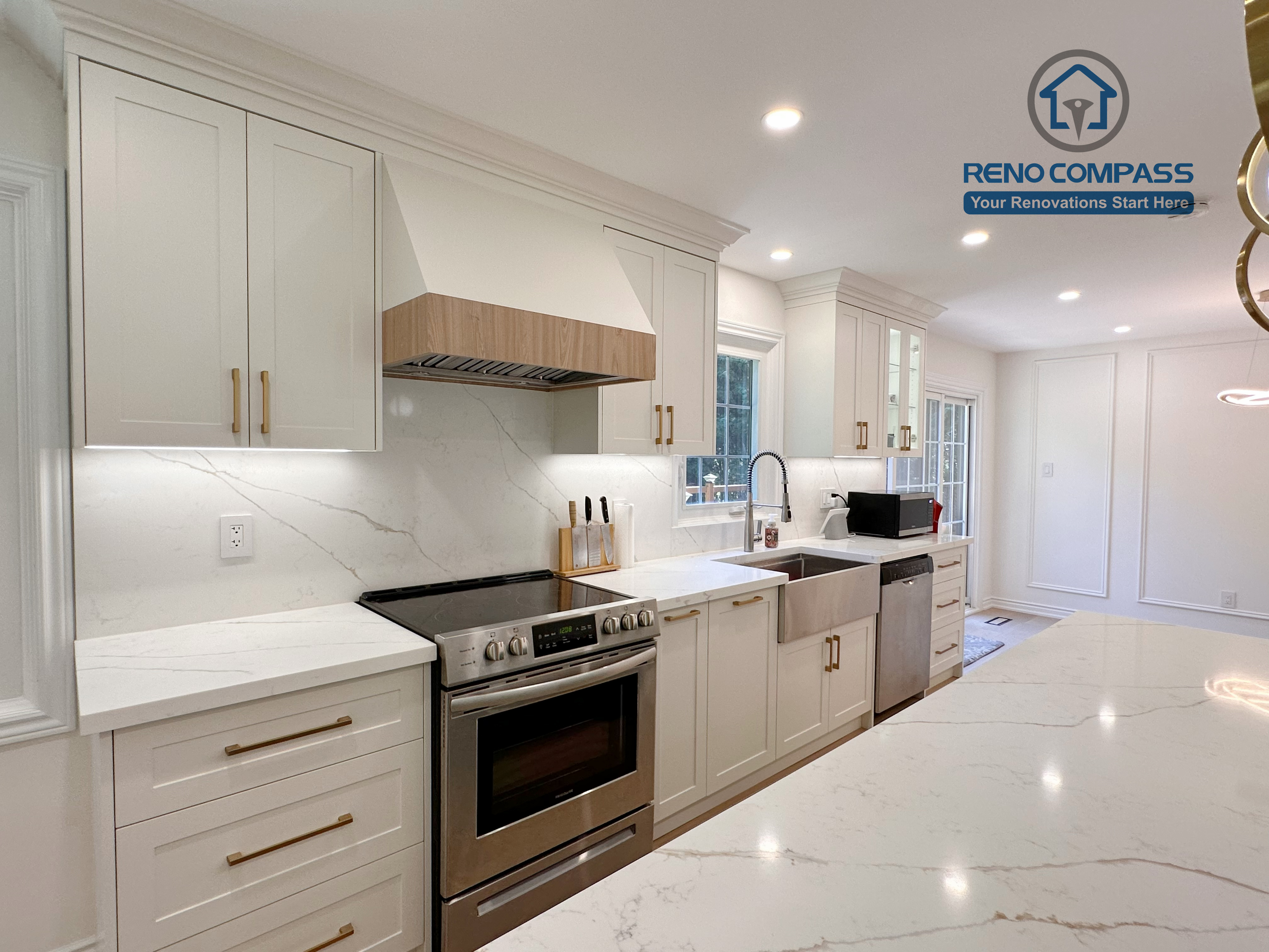 This Markham kitchen renovation showcases custom white cabinetry with brass hardware, quartz countertops, and a fully integrated appliance wall featuring a stainless steel range and farmhouse-style sink. Under-cabinet lighting and a clean backsplash enhance both functionality and visual clarity. Completed by a professional Toronto renovation company, Reno Compass Inc., the design emphasizes practicality, refined detailing, and long-term performance.