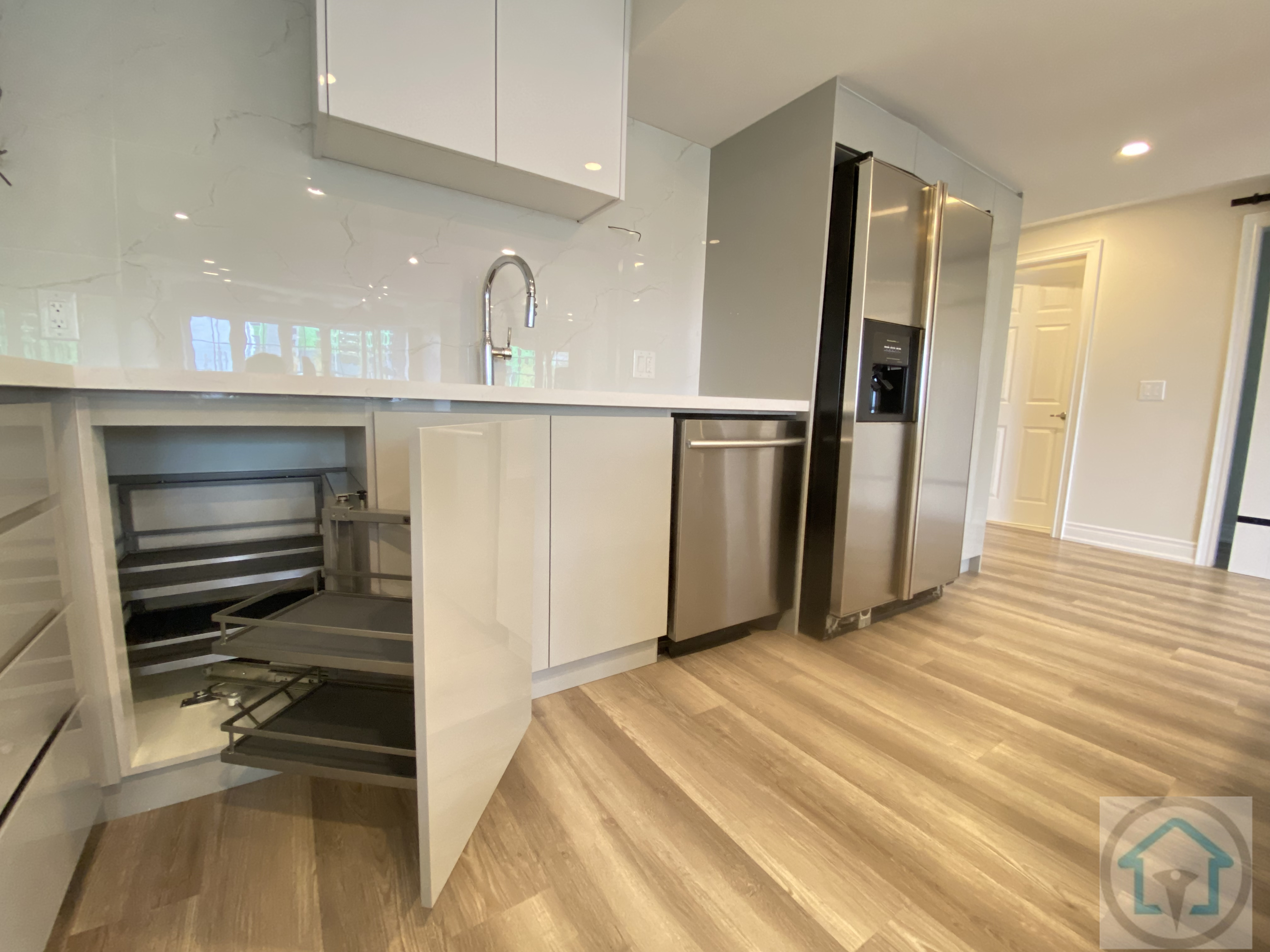 This Newmarket basement renovation highlights modern kitchen details, including integrated pull-out storage, sleek cabinetry, and stainless steel appliances. Thoughtful storage solutions and clean finishes improve functionality and efficiency within the basement kitchen layout.
