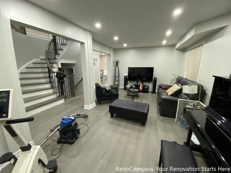 This Mississauga interior renovation features a modern open-concept living space with upgraded flooring, smooth ceilings, and recessed pot lights that create a bright and welcoming atmosphere. The redesigned layout highlights a custom staircase feature wall, contemporary trim work, and a seamless transition between living and dining areas. Completed by a professional Toronto renovation company, this renovation focuses on enhancing space flow, lighting quality, and overall home comfort while adding long-term value and a clean modern aesthetic.