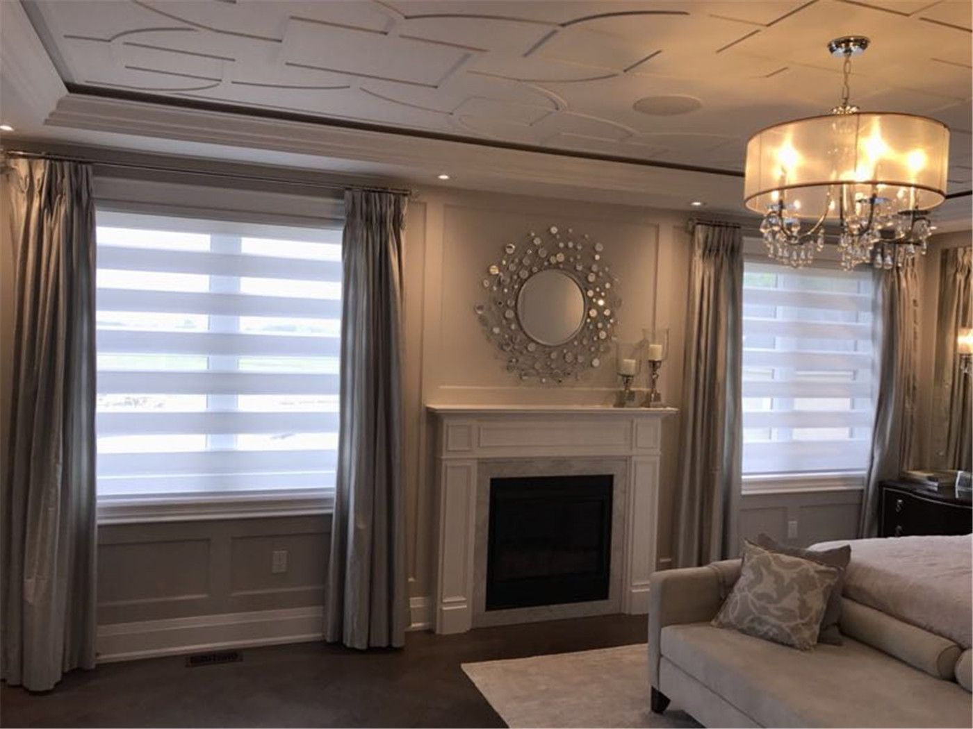 Modern living room in Toronto featuring layered window treatment with zebra blinds and full-length curtains. This combination provides flexible light control, privacy, and a clean, elegant finish that complements the fireplace and custom ceiling design.