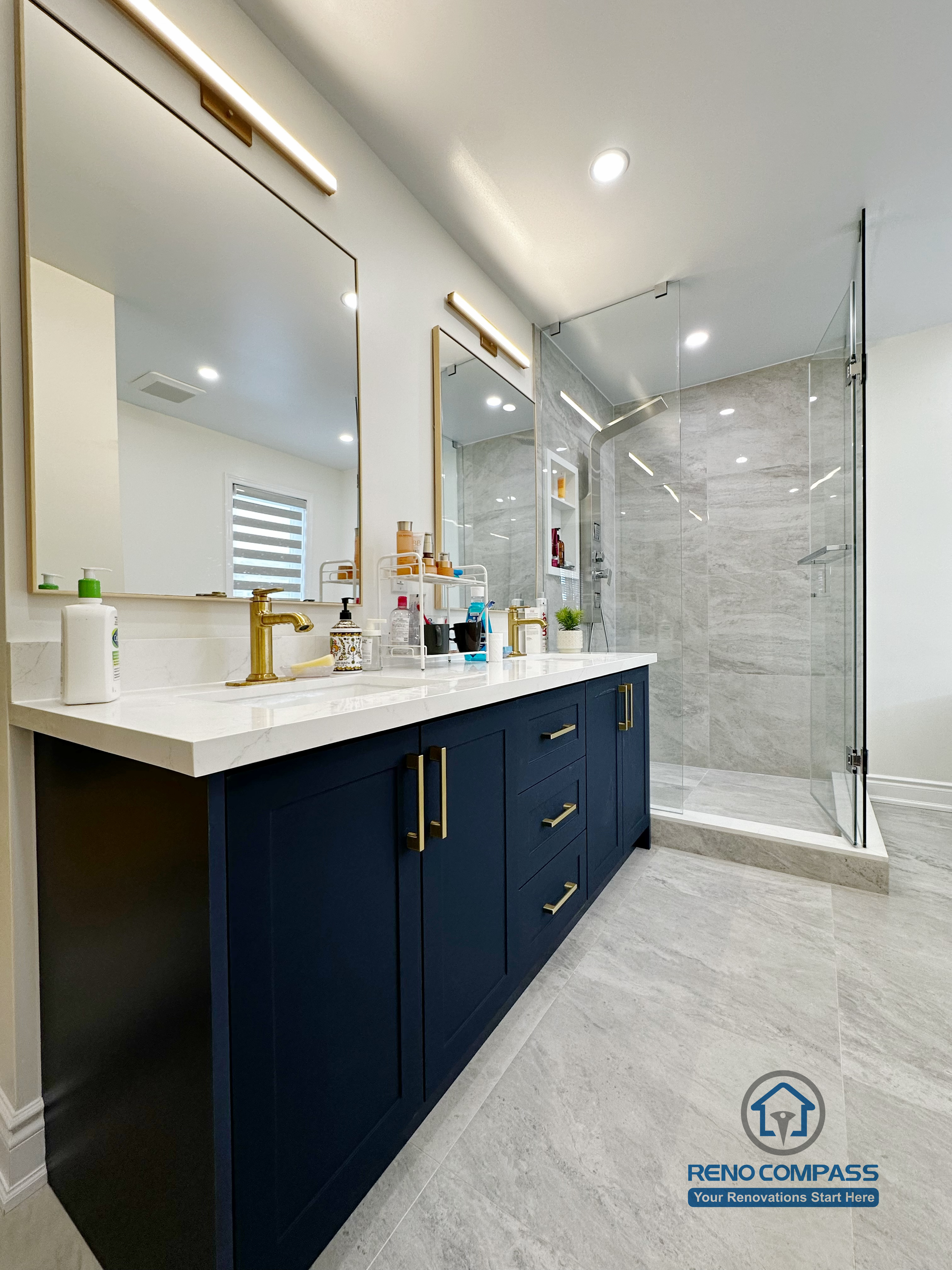 Master bathroom renovation in Markham featuring a frameless glass shower, large-format tile finishes, a custom vanity with matte black cabinetry, and brass fixtures. The design combines clean lines, efficient layout, and a refined modern aesthetic for everyday comfort.
