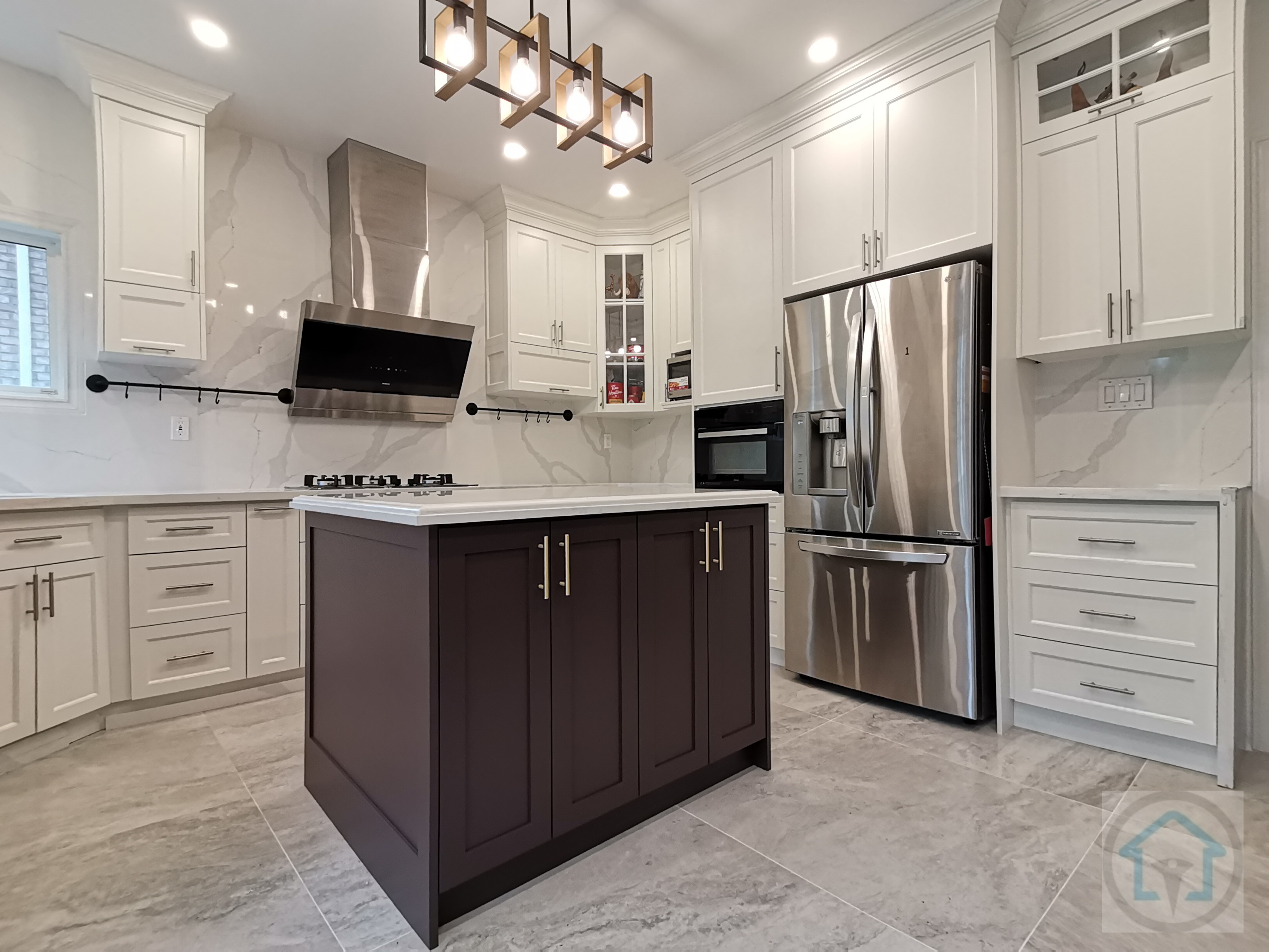 This modern kitchen renovation features a timeless white cabinetry design paired with a bold dark-toned island to create strong visual contrast and functional balance. Full-height custom cabinets maximize storage while maintaining clean lines, complemented by large-format marble-look porcelain tiles that enhance brightness and spatial continuity. The oversized island provides generous prep space and seating, making it the focal point for everyday cooking and entertaining. Stainless steel appliances, integrated lighting, and a statement range hood elevate both performance and aesthetics. Designed and completed by a professional Toronto renovation company, this kitchen renovation reflects a thoughtful blend of elegance, durability, and modern living—ideal for homeowners seeking long-term value and refined interior design.