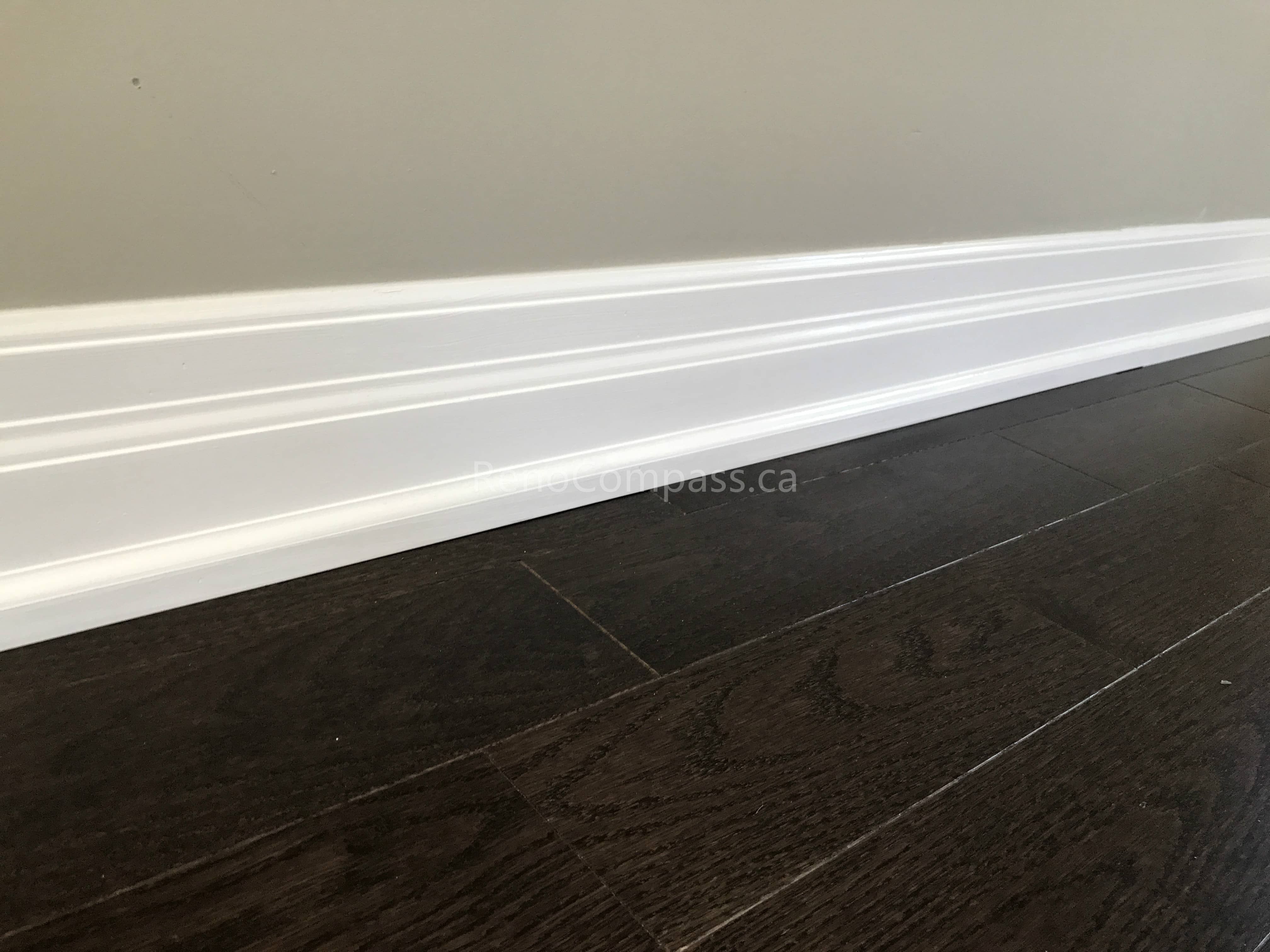This Markham flooring renovation project features dark engineered hardwood flooring paired with crisp white baseboard trim for a clean and modern finish. The deep wood tone enhances contrast against neutral walls, creating a warm and elegant interior atmosphere. Professionally installed by a trusted Toronto renovation company, the flooring ensures durability, smooth alignment, and seamless transitions throughout the space.