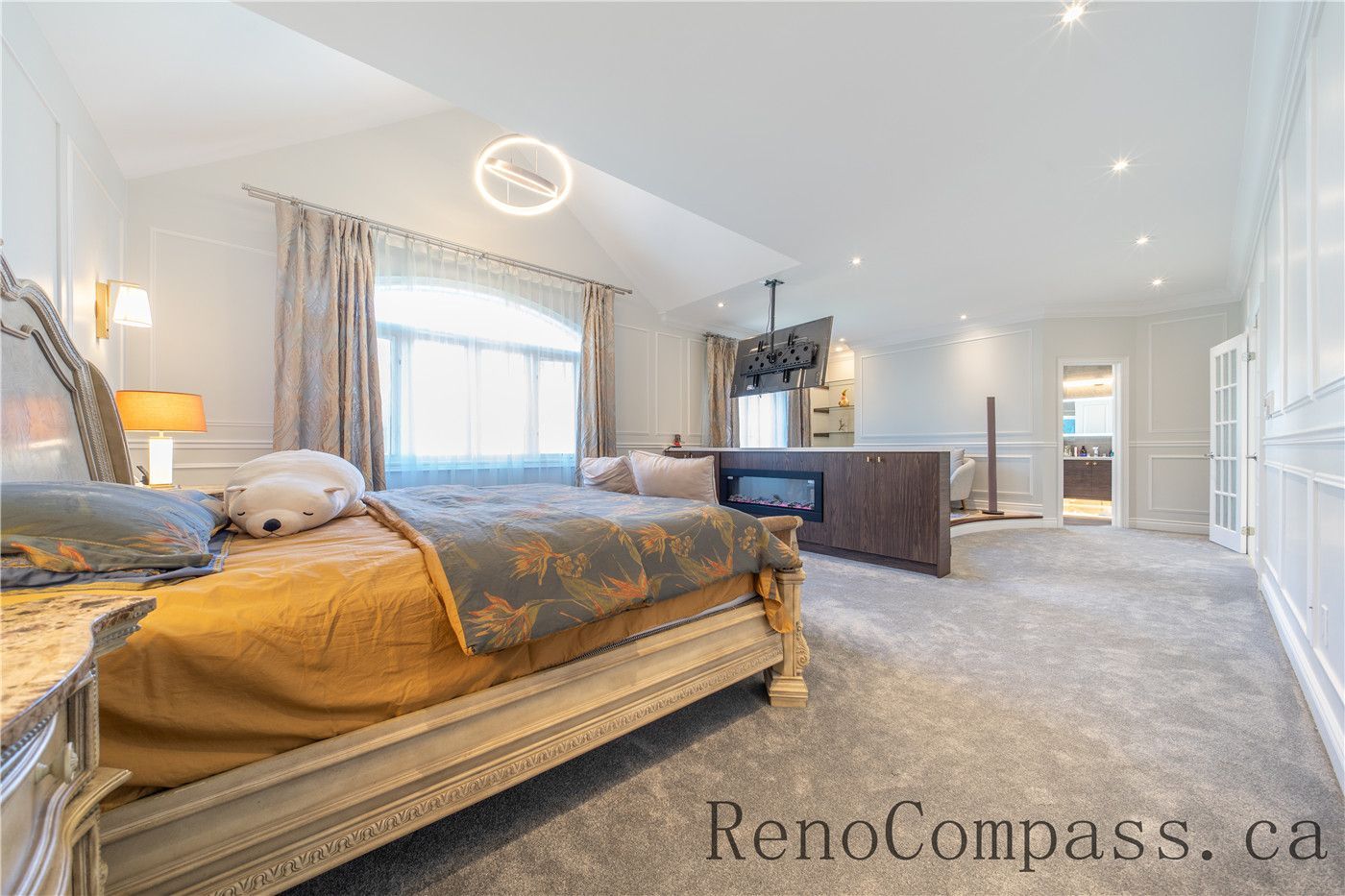 This Richmond Hill entire house interior renovation features a spacious master bedroom suite with a cozy sitting area, built-in fireplace feature, and elegant wall paneling. Soft carpeting, large windows, and warm lighting create a comfortable and luxurious retreat designed for relaxation. Completed by a trusted Toronto renovation company, this master bedroom renovation combines modern comfort, refined finishes, and functional layout to elevate everyday living.